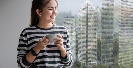 Womenstanding and  looking out of a high rise building in a Singapore property